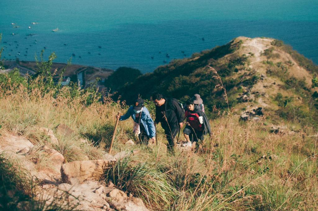 family walking on trail along the ocean