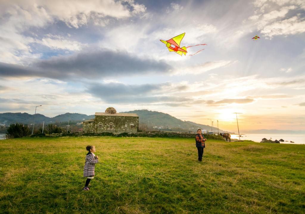mother and daughter flying a kite on a sunny day