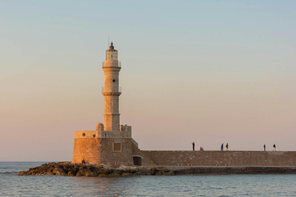 a lighthouse on a long pier on the ocean