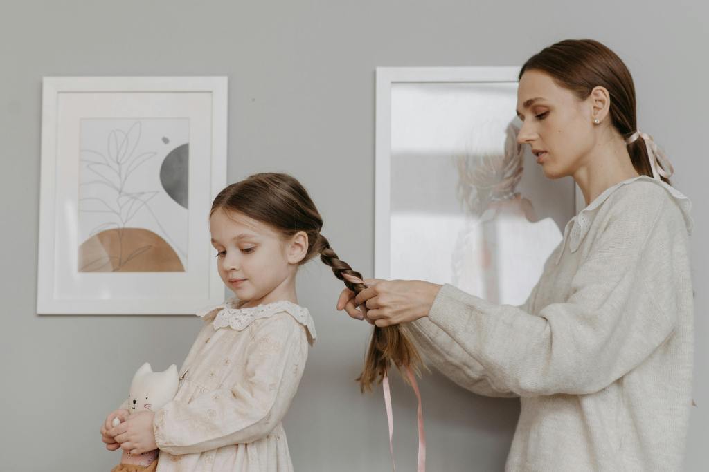 mother braiding daughters hair
