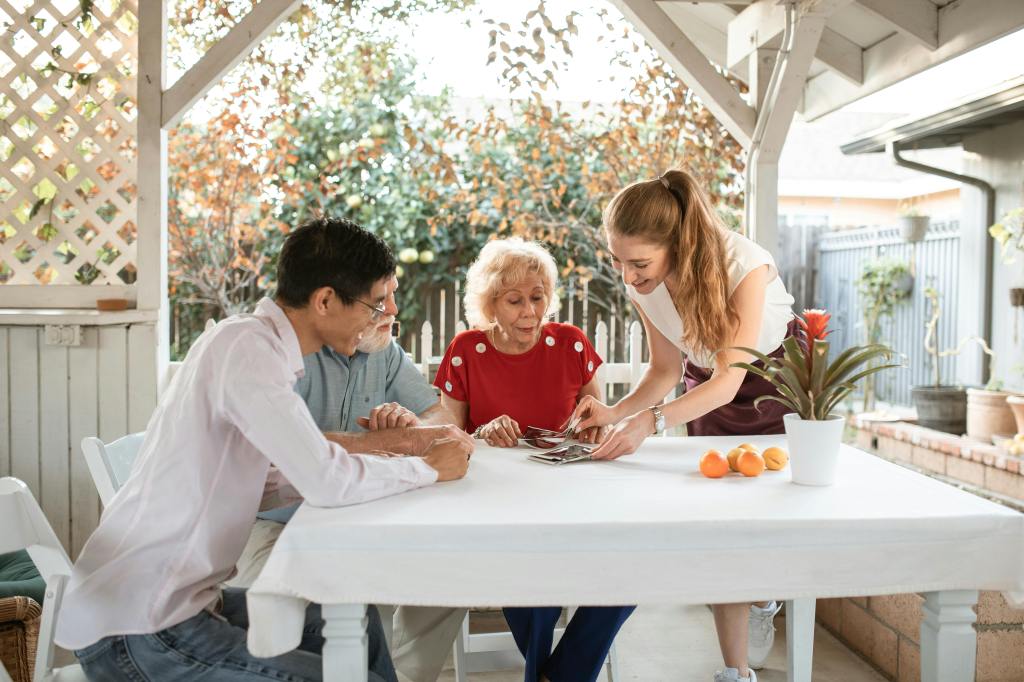 grand kids gather with grandparents to look a family photos while in the backyard