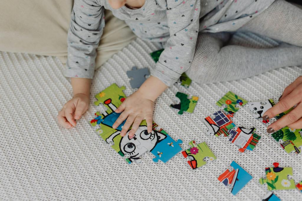 a child putting a puzzle together with their mother